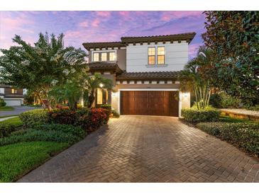 Beautiful two-story home featuring a paver driveway and meticulously maintained landscaping at 1570 Marinella Dr, Palm Harbor, FL 34683