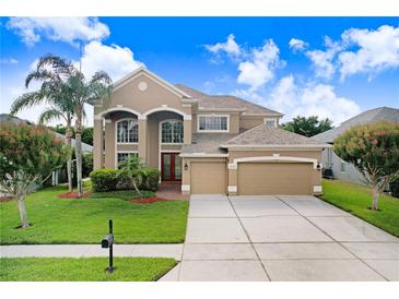 Stunning two-story home featuring a manicured lawn, mature trees, and a convenient two-car garage at 23325 Abercorn Ln, Land O Lakes, FL 34639