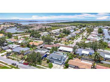 Expansive aerial view of waterfront neighborhood with canals, marina, and single Gathering homes under a sunny, blue sky at 4710 Travertine Dr, Tampa, FL 33615