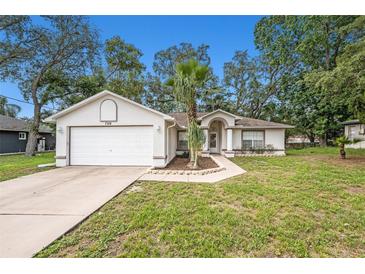Charming single-story home featuring a manicured lawn, and a two-car garage at 7318 Lamplighter St, Spring Hill, FL 34606