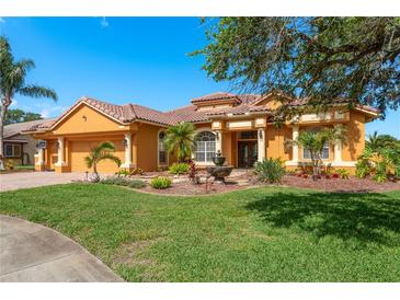 Stunning single Gathering home features a meticulously landscaped front yard, terracotta roof, and charming water fountain feature at 800 Belted Kingfisher S Dr, Palm Harbor, FL 34683