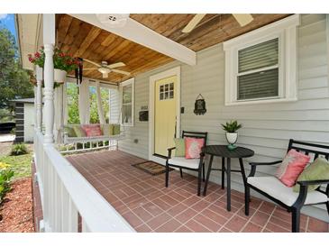 Inviting front porch with swing, seating, and classic brick flooring at 1003 W Indiana Ave, Tampa, FL 33603