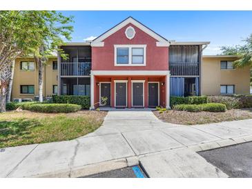 Inviting condo building with colorful facade, screened balconies, and neatly landscaped grounds at 10511 Waterview Ct # 10511, Tampa, FL 33615