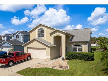 Charming two-story home boasts a two-car garage, landscaped yard, and inviting entryway at 1246 Ocean Reef Rd, Wesley Chapel, FL 33544