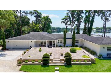 Beautiful single-story home with lush landscaping, brick-paved entry, and stunning lake views at 16315 Lonely Ln, Odessa, FL 33556