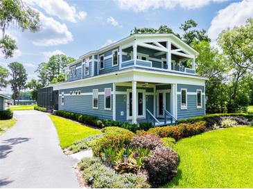 Charming two-story home with a manicured lawn and landscaped garden beds at 16603 Hutchison Rd, Odessa, FL 33556