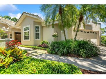 Charming single-Gathering home with mature landscaping, stone walkway, and attached two-car garage at 423 Fan Palm Ne Ct, St Petersburg, FL 33703