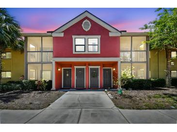 Charming two-story condo with a colorful red exterior, screened-in balconies, and well-maintained landscaping at 5705 Baywater Dr # 5705, Tampa, FL 33615