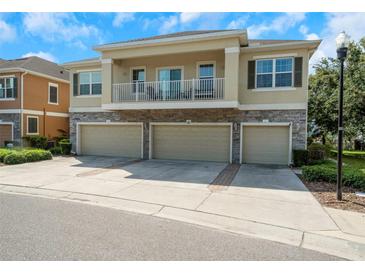 Attractive townhome featuring a stone facade, balcony, and multiple garage bays for ample parking and storage at 7001 Interbay Blvd # 242, Tampa, FL 33616