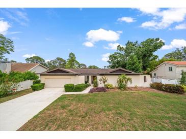 Charming single-story home with a well-manicured lawn and mature landscaping, complete with a two-car garage at 14175 Feather Sound Dr, Clearwater, FL 33762