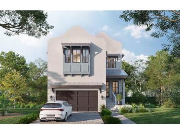 Charming two-story home with a stucco facade, a two-car garage, and professionally landscaped front yard at 143 Chesapeake Ave, Tampa, FL 33606