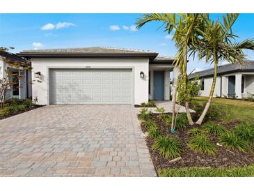 Charming single-story home featuring a paver driveway, two-car garage, and professionally landscaped yard at 1978 Pepper Grass Dr, North Port, FL 34289