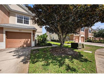 Charming townhouse featuring a well-manicured lawn and an attached single-car garage at 2542 Glenrise Pl, Wesley Chapel, FL 33544