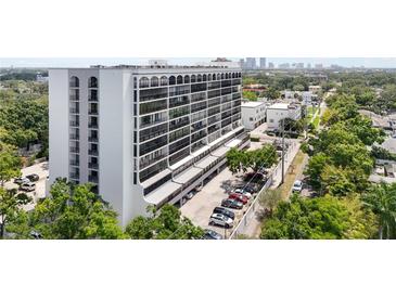 Exterior shot of a high-rise building featuring many balconies, parking, and manicured trees at 3211 W Swann Ave # 605, Tampa, FL 33609