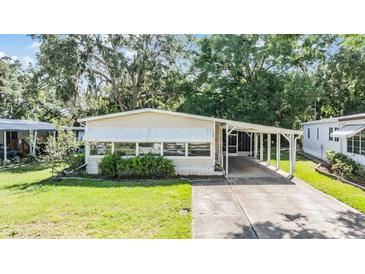 Charming single-story home featuring a covered carport and well-maintained front lawn at 3542 Castle Dr, Zephyrhills, FL 33540