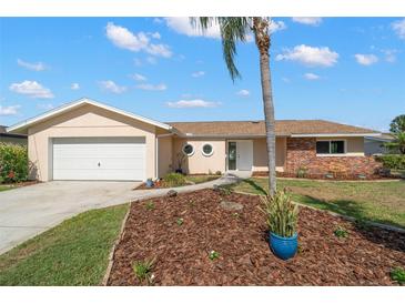 Charming single-story home with tan exterior, brick accents, and a well-maintained landscaped front yard at 3932 Shore Acres Ne Blvd, St Petersburg, FL 33703