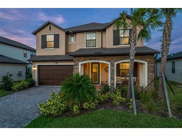 Charming two-story home featuring a stone facade, covered porch and well-manicured landscaping at 3952 Aldea Way, Wesley Chapel, FL 33543