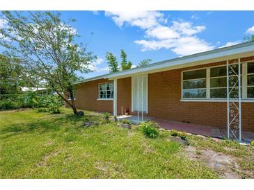 Charming single-story brick home with a well-maintained lawn and decorative front door at 6104 Palm Ave, Gibsonton, FL 33534