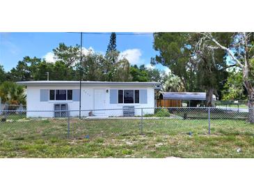 Charming single-story home featuring a fenced yard and covered parking at 6825 Hammock Rd, Port Richey, FL 34668