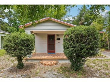 Charming single-story home featuring a brick porch and neatly trimmed shrubbery in the front yard at 7511 N Ola Ave, Tampa, FL 33604