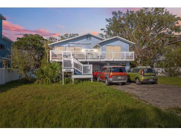 Charming two-story home with a spacious front deck and well-maintained yard with parking for multiple cars at 108 Shore Dr, Tarpon Springs, FL 34689
