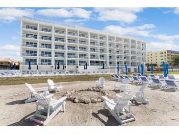 Beautiful beachfront condo building with private beach access and comfortable lounge chairs at 11500 Gulf Blvd # 513, Treasure Island, FL 33706