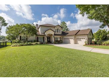 Stately home featuring a lush green lawn, attached three car garage, and manicured landscaping at 1834 Daiquiri Ln, Lutz, FL 33549