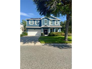 Charming two-story blue home with a well-maintained front yard and a two car garage at 2325 Via Bella Blvd, Land O Lakes, FL 34639
