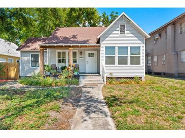 Charming single-Gathering home featuring a cozy front porch with seating and a well-maintained yard at 2911 N Jefferson St, Tampa, FL 33602