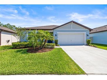 Charming single-story home with a well-manicured lawn, complemented by mature landscaping and a two-car garage at 30273 Marquette Ave, Wesley Chapel, FL 33545