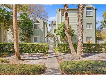 Charming two-story condo buildings with a walkway and gate surrounded by lush landscaping at 607 S Albany Ave # 1, Tampa, FL 33606