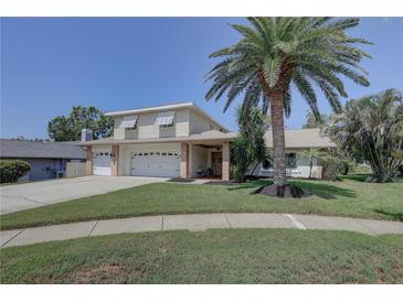Charming two-story home featuring a well-manicured lawn, mature landscaping, and a spacious two-car garage at 7600 Drew Oak Dr, Seminole, FL 33772