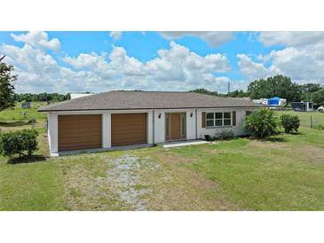 Charming single-story home featuring an attached two-car garage and manicured front lawn at 9780 Allen Rd, Lithia, FL 33547