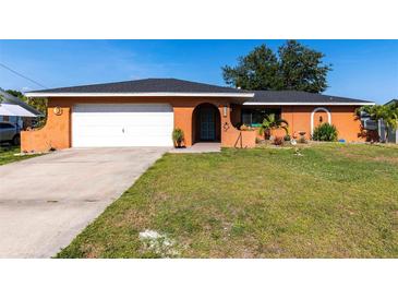 Charming single-story home with a well-maintained lawn, attached garage, and vibrant exterior paint at 3254 Great Neck St, Port Charlotte, FL 33952