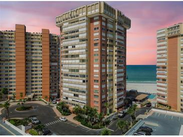 A high-rise condo building overlooks the ocean with lush landscaping and plenty of parking spaces at 17920 Gulf Blvd # 208, Redington Shores, FL 33708