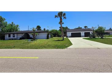 Charming single story home featuring a spacious lawn and a two car garage at 20295 Lorenzo Ave, Port Charlotte, FL 33952