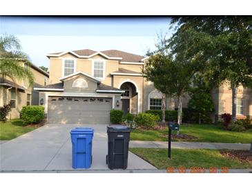 Two-story home with a two-car garage, complemented by a well-maintained lawn and a welcoming front entrance at 20420 Carolina Cherry Ct, Tampa, FL 33647