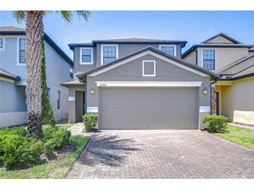 Charming two-story home with a two-car garage, a brick driveway, and lush landscaping at 2723 Garden Falls Dr, Brandon, FL 33511