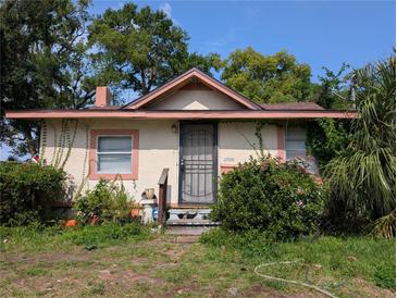 Charming single-story home with a secure metal door and a lush garden surrounding the front entrance at 3706 N 36Th St, Tampa, FL 33610