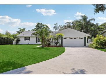 Charming single-story home featuring a well-manicured lawn, a two-car garage and beautiful curb appeal at 71 Flamingo Cir, Safety Harbor, FL 34695