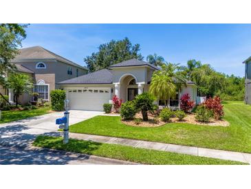 Charming single-story home featuring a well-manicured lawn and beautiful landscaping at 19412 Heritage Harbor, Lutz, FL 33558
