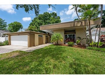 Modern home featuring a well-manicured lawn and a stylish contemporary design with a side-entry two car garage at 4304 N River View Ave, Tampa, FL 33607