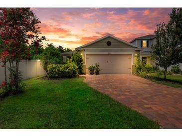 Charming single-Gathering home featuring a brick driveway, a two-car garage and sunset views at 7302 Sunshine Bridge Ave, Gibsonton, FL 33534
