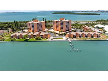 Stunning aerial view of waterfront condos and pier access with a serene ocean backdrop at 7432 Sunshine Skyway S Ln # 402, St Petersburg, FL 33711