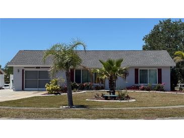 Charming single-story home with a well-manicured lawn, complemented by vibrant landscaping and curb appeal at 6405 Klaus Ct, Port Charlotte, FL 33981