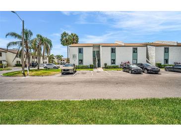 Condominium exterior featuring tropical landscaping, palm trees, ample parking, and a well-maintained façade at 776 116Th N Ave # 1110, St Petersburg, FL 33716