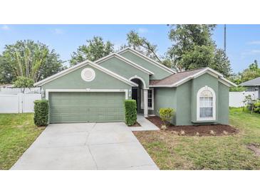 Charming single-story home showcasing a well-maintained lawn and attached two-car garage at 9712 White Barn Way, Riverview, FL 33569