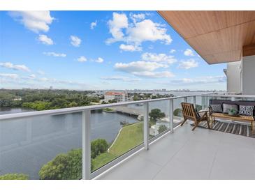 Enjoy a breathtaking waterfront view from this luxury balcony with comfortable seating and privacy glass railing at 1020 Sunset Point Rd # 712, Clearwater, FL 33755
