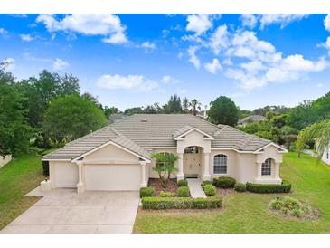 Stunning single-story home featuring manicured landscaping and an attached three car garage at 1212 Baycove Ln, Lutz, FL 33549