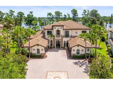 Elegant two-story home showcasing a well-manicured lawn, palm trees, and a circular driveway with a unique brick design at 17301 Ladera Estates Blvd, Lutz, FL 33548